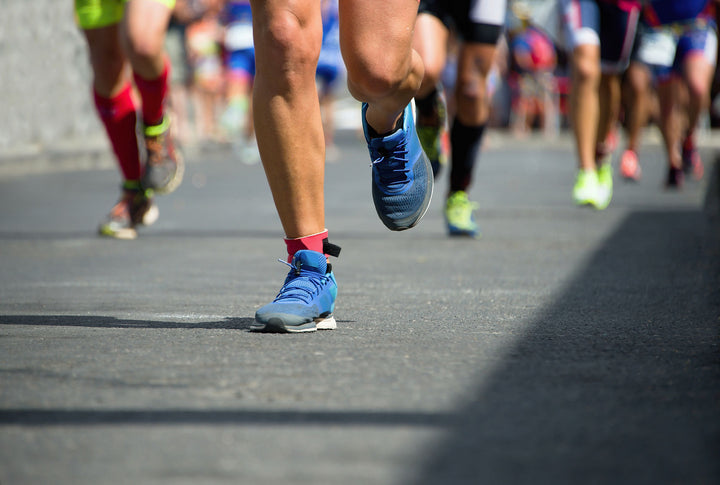 image shows a cluster of people's feet and legs running in a marathon race