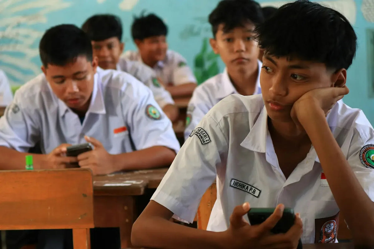Teenagers using their phones at school